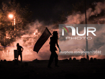Bahrain , Abu Saiba - protester holding Bahrain flag during the clashes with riot police , demonstration with title 