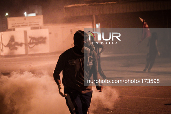 Bahrain , Abu Saiba - protester running and behind him cloud of tear gas , demonstration with title 