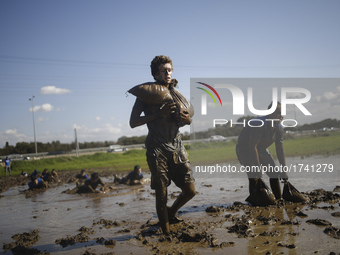 Israeli teenagers walk with heavy sandbags through mud as they take part in an annual combat fitness training competition in preparation for...