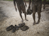 Israeli teenagers take their shoes covered in mud during an annual combat fitness training competition in preparation for the compulsory arm...