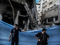 A Palestinian  looks at debris and remains of cars after what police said was an Israeli air strike that destroyed a nearby house in an in G...