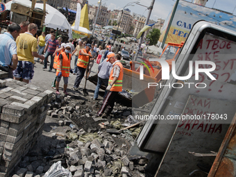 Employees of utility services remove barricade in the center of Kiev. Inscription on the lightbox says 