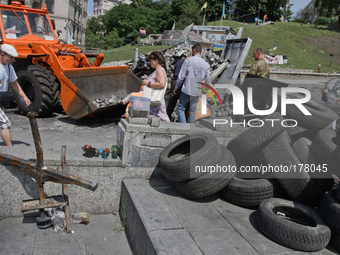 People pass by the street of Instytutska as employees of utility services remove barricade in the center of Kiev. (