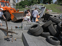 People pass by the street of Instytutska as employees of utility services remove barricade in the center of Kiev. (