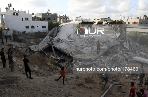 Palestinians inspects a heavily damaged building after it was hit by an Israeli airstrike in Beit Lahiya, northern Gaza Strip July 15, 2014....