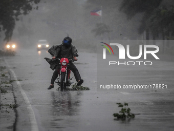 A motorist brave strong winds and rain as he travels along a highway as Typhoon Rammasun barrels across Manila on July 16, 2014. Typhoon Ram...