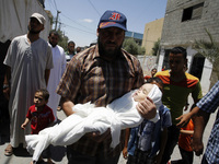 One relatives of five-month-old Palestinian child, Lma  al-Satary , carries body a during his funeral in Rafah, the southern Gaza Strip on J...