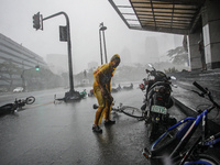 Makati City, Philippines - A man attempts to gain his balance after losing control of his bicycle caused by strong winds as Typhoon Rammasun...