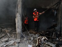 Palestinian firefighters extinguish a fire at a house destroyed during an Israeli strike, on July 16, 2014, in Gaza City. So far, Israel's c...