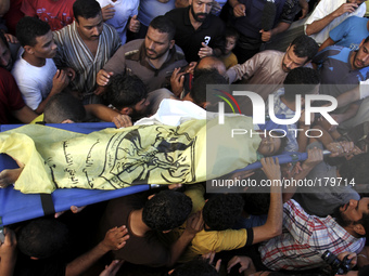 Palestinian mourners carry the bodies of one of four boys from Baker family killed in an Israeli strike, during their funeral in Gaza City o...