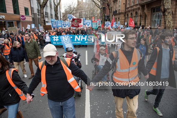 Protesters carry flags through central London during a demonstration in support of the NHS on March 4, 2017 in London, England. Thousands ma...