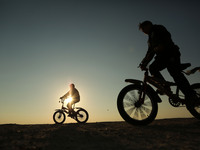  Palestinian boys rides  bicycle during sunset in Gaza City, on March 5, 2017. (