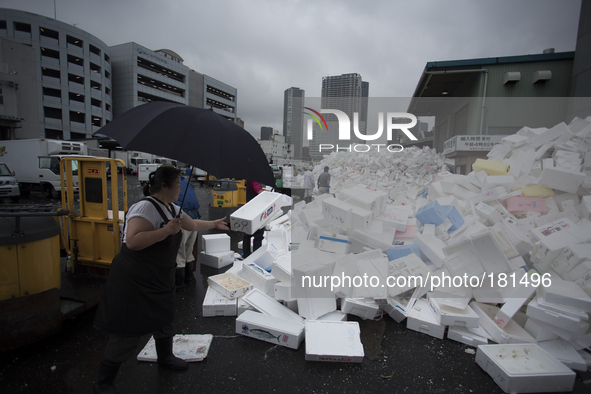TOKYO, Japan A woman throws empty ice boxes up to be stored at Tsukiji Fish Market on july 7, 2014. The Tsukiji fish market located in Tokyo...