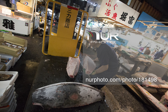 TOKYO, Japan A Tsukuji Fish Market employer transports freezed Bluefin Tunaat Tsukiji Fish Market on july 7, 2014. The Tsukiji fish market l...