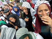 Protesters paint their faces in Palestinian colours to show support for the people of Gaza. Thousands protested in front of the Israeli Emba...