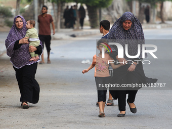 Palestinians women and children flee from their houses at Al Shejaiyaa neighbourhood in the east of Gaza City along the border between Israe...