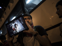 A man holds a table showing photographs of injured and dead Palestinian children during a protest outside the Israeli Consulate in Istanbul...