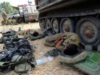 UNSPECIFIED, ISRAEL - JULY 19, 2014: Israeli soldiers sleep next to an APC in an army deployment area near Israel's border with the Gaza Str...