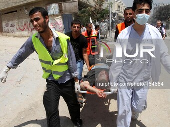 Medic helps a Palestinian in the Shejaia neighbourhood, which was heavily shelled by Israel during fighting, in Gaza City July 20, 2014. At...