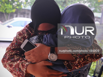 Normah Ismail, right, embraces her niece, Nur Diyana Yazeera, left, daughter of Malaysia Airlines, flight attendant, Dora Kassim, onboard th...