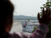 An unidentified child watches Malaysia Airlines planes taxied on the tarmac of Kuala Lumpur International Airport as it enters the second da...