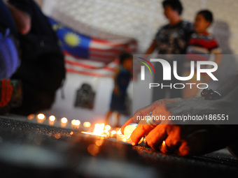 People lights candle during a special prayer vigil for the ill fated Malaysia Airlines, MH17 in Kuala Lumpur, Malaysia, Tuesday, July 22, 20...