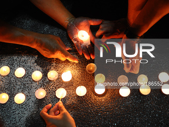 People lights candle during a special prayer vigil for the ill fated Malaysia Airlines, MH17 in Kuala Lumpur, Malaysia, Tuesday, July 22, 20...