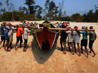 Indian Fisher men  carry  boats  in the fish industry Area . The coast of the Bay of Bengal in Sunderbans delta, West Bengal, India on 2nd A...