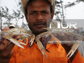 Indian Fisher men showing Crabs sit at  the fish industry Area . The coast of the Bay of Bengal in Sunderbans delta, West Bengal, India on 2...