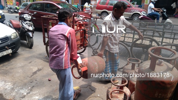 A Customer carrying Liquid Petroleum Gas (LPG) cylinders at Central Kolkata in India ,Subsidised LPG cylinder price hiked by Rs5.57, ATF cut...