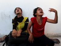 Palestinian girls cry after their father was killed in UN School in the northern Beit Hanun district of the Gaza Strip on July 24, 2014, aft...