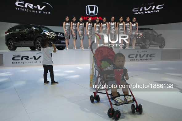 A girl take a photo mobile phone at Honda cars on display during the 38th Bangkok International Motor show in Bangkok, Thailand, on April 7,...