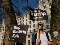Demonstrators hold placards during a protest against US President Donald Trump's decision to launch attacks against Syrian targets, organise...
