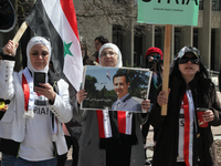 Syrian woman holds a poster of Syrian President Bashar al-Assad during a protest against US President Donald Trump's decision to launch airs...