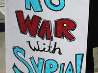 Woman holds a sign saying 'No War with Syria' during a protest against US President Donald Trump's decision to launch airstrikes against Syr...