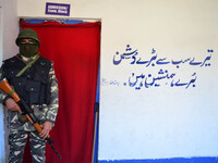An Indian Paramilitary force personal  stands guard outside a  polling station in central kashmir's Budgam district during By-Polls of India...