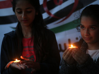 Palestinian girls hold a candle during a gathering in Gaza City on April 10, 2017 in solidarity with the victims of the twin church bombings...