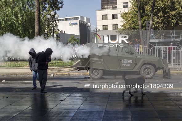 A police car launches tear gas against demonstrators.
Thousands of students marched through the main avenue of Santiago, on April 11, 2017,...