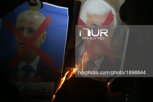 Palestinian youths burn a portrait of Palestinian leader Mahmud Abbas and a crossed poster depicting Prime Minister Rami Hamdallah during a...