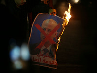 Palestinian youths burn  a crossed poster depicting Prime Minister Rami Hamdallah during a protest against the Israeli blockade of the Gaza...