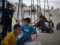 Palestinian children enjoys a swing ride as the sun sets on a beach in Gaza City April 14, 2017. 
 (