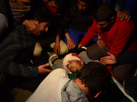 Relatives And friends sit next to the body of body of  Shabir Ahmed, a teenage boy During his funeral prayers  in Srinagar, Indian controlle...