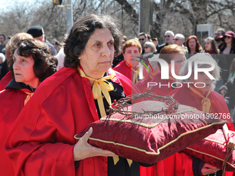 A participant carries a 'crown of thorns' on a small pillow during the Good Friday procession in Little Italy in Toronto, Ontario, Canada, o...