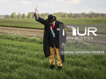 A man holds a twig cross just before he puts it on a field crop during the traditional horse riding procession on Easter Monday in Zernica v...