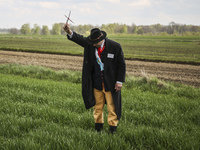 A man holds a twig cross just before he puts it on a field crop during the traditional horse riding procession on Easter Monday in Zernica v...