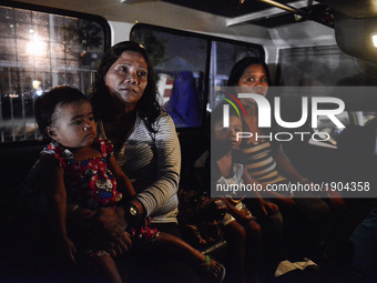 Ruth Jane Sombrio (R), together with her mother and children, ride a van as they head to the seaport to leave by ferry to the province, in M...