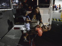 Ruth Jane Sombrio carries her son as they arrive at the seaport to leave by ferry to the province, in Manila, Philippines, March 31, 2017. P...