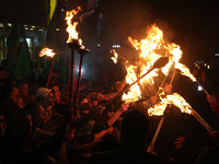 Hamas supporters hold torches during a protest against Palestinian President Mahmoud Abbas and his Prime Minister Rami Hamdallah, at Shijaiy...