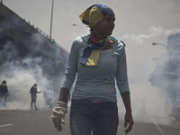 A Demonstrator clash with police during a march against Venezuelan President Nicolas Maduro, in Caracas on April 19, 2017. Venezuelans took...