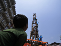 A Kid watching as Devotees arranging piles of wood for making the chariot of Idol Rato Machindranath 'Rain of God' at Pulchowk, Laltipur, Ne...